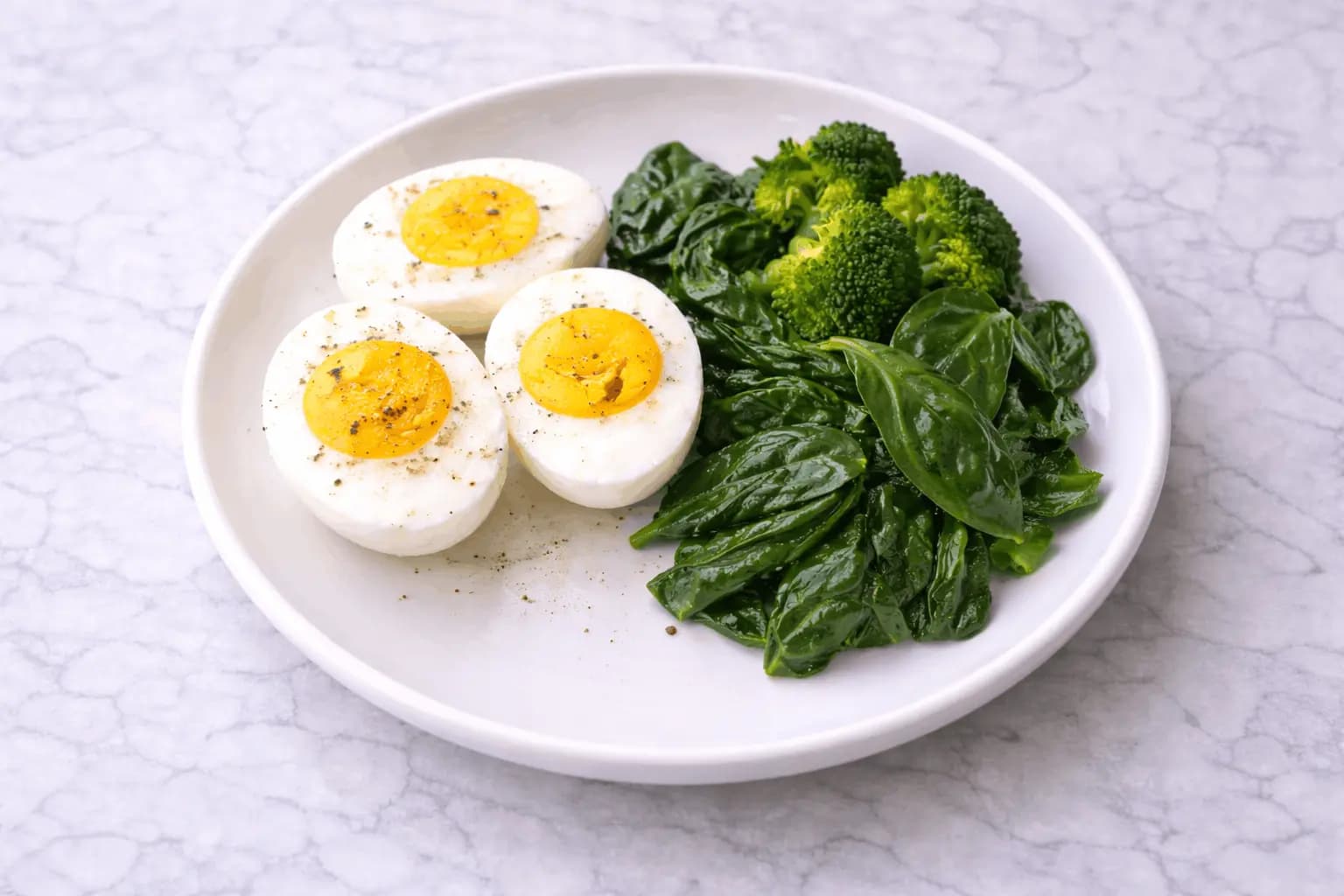 Simple egg diet meal showing hard-boiled eggs with minimal vegetables on white plate representing restrictive eating plan